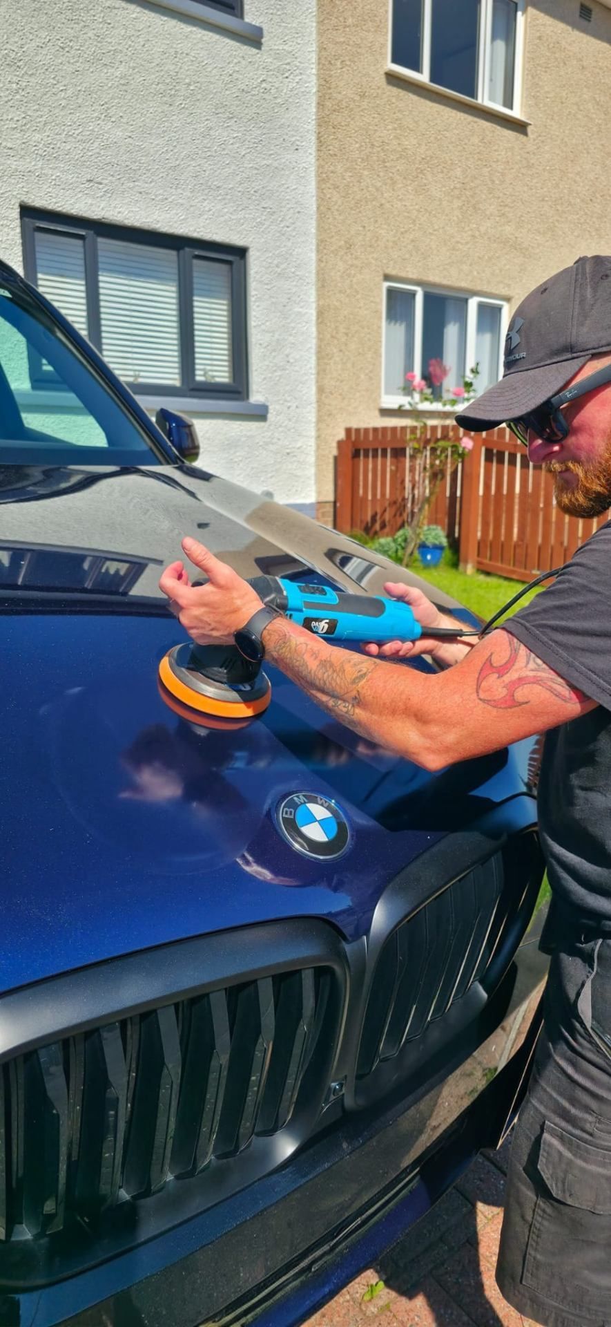 Owner polishing BMW bonnet — hands-on craftsmanship